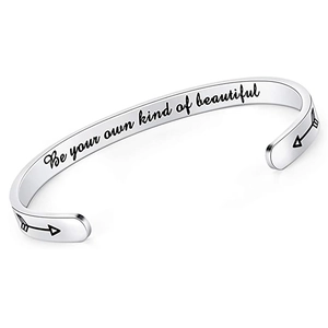 Detailed view of 'Be your own kind of beautiful' engraving on silver cuff bracelet