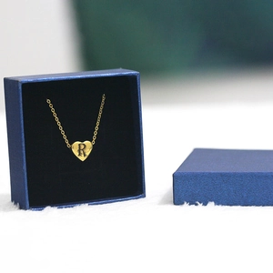 Gold heart pendant necklace with letter R engraving in a blue square jewelry gift box
