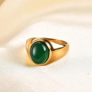 Macro d'une bague en acier inoxydable doré 18K avec pierre ovale verte sur soie