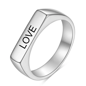 Makro-Detail eines silbernen Edelstahlrings mit graviertem LOVE-Schriftzug auf rechteckiger Fläche