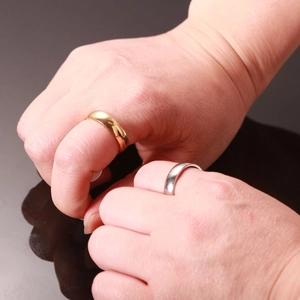 Anillos pulidos de 5mm en acero inoxidable oro y plata mostrados en las manos del modelo