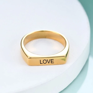 Nahaufnahme eines 4mm Edelstahlrings in Gold mit lasergraviertem LOVE-Schriftzug