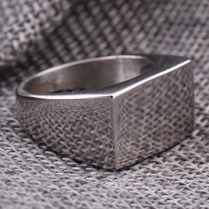 Gros plan d'une bague chevalière polie en acier inoxydable avec gravure S925 et face carrée