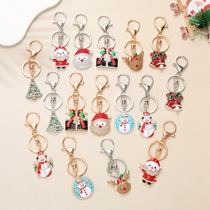Gros plan de charms de Noël en émail coloré avec Père Noël et sapin pour porte-clés