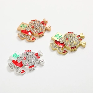 Detailed view of rhinestone-encrusted cartoon dragon charms in gold, rose gold and silver
