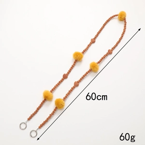 Detail view of a 60cm beaded crossbody phone strap with yellow faux fur balls