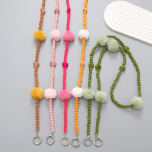 Detail of colorful plush pompom bead phone straps with metal rings for crossbody use