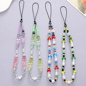 Detail of beaded phone wrist straps featuring gummy bears and colorful resin mushroom beads