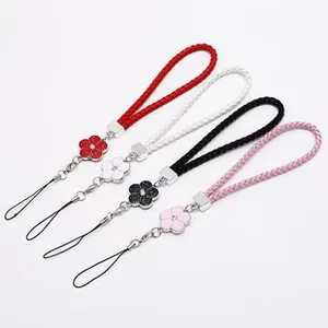 Detail of colorful braided phone wrist straps with floral pendants and silver hardware