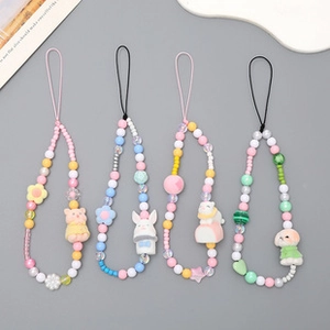 Detailed view of four colorful beaded phone wrist straps with cute cartoon animal charms