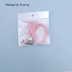 Pink woven wrist strap with silver metal lobster clasp in clear packaging