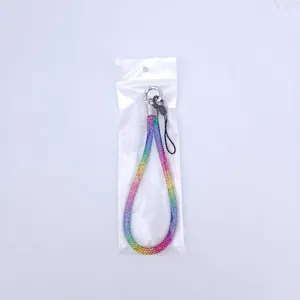 Rainbow gradient rhinestone phone wrist strap with silver metal ring in clear packaging
