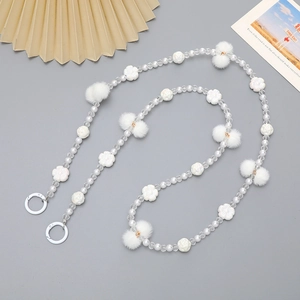 Witte kralen telefoonketting met parels, pluche ballen en bloemen op grijze basis