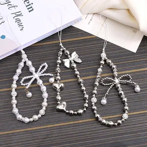 Elegant bow and pearl phone charm set with silver metal beads and heart pendant accents