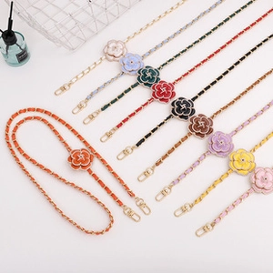 Detail of luxury rhinestone phone crossbody strap featuring camellia flower and gold chain