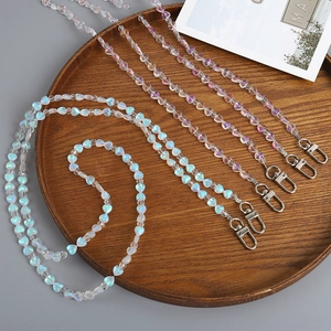 Iridescent heart beaded crossbody lanyard with silver lobster clasp on wooden tray
