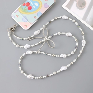 Detail view of acrylic bow and pearl phone strap with lobster clasps and beads