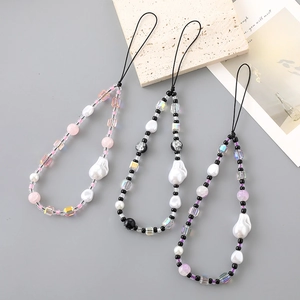 Three beaded phone charms with baroque pearls and crystals on a minimalist background