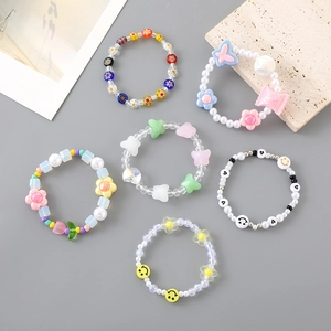 Set of 6 colorful acrylic beaded bracelets with flower, butterfly, and smiley face charms