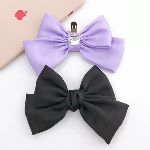 Close-up of elegant purple and black satin bow clips for DIY shoe or hair accessories