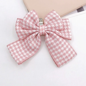 Detailed view of pink houndstooth bow charm with a secure metal spring clip for shoes