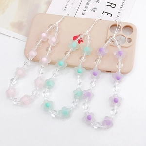 Detailed shot of frosted acrylic flower beads on phone charms in pink, green, and purple