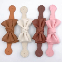 Détail d'accessoires en cuir en forme de nœud en marron, crème et rose tendre