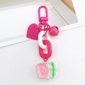 Détail de la chaîne porte-clés en acrylique rose avec breloque cœur et logo gravé