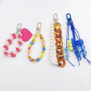 Close-up of candy color heart charms, smiley beads and pearl acrylic keychains