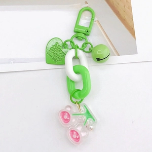 Détail du porte-clés cœur en acrylique vert avec plaque et breloque cerise