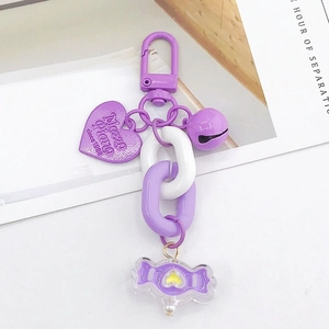 Détail du pendentif cœur en acrylique violet avec clochette et bonbon pour AirPods