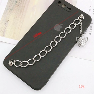 Détail de la chaîne de téléphone argentée avec breloque papillon et coque mate