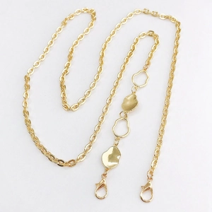 Detailed macro of gold zinc alloy chain with irregular metal accents and lobster clasps