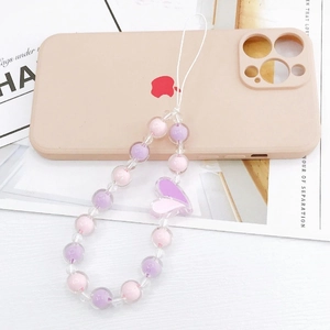 Dragonne de téléphone perlée rose et violette avec breloque cœur 3D sur une coque
