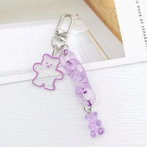 Detailed macro view of purple candy bear keychain with acrylic links and glitter tag