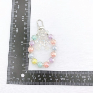 Colorful macaron bear charm with iridescent beads and silver spring clasp on white background