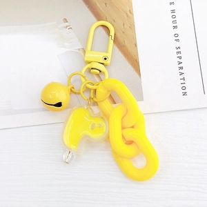 Détail d'un porte-clés fantôme en acrylique jaune vif avec mousqueton et chaîne plastique