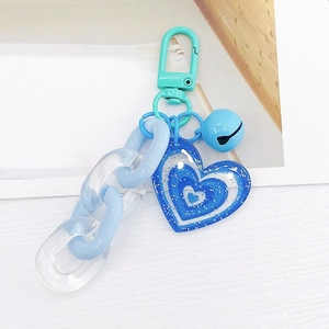 Détail du porte-clés chaîne acrylique bleue avec pendentif cœur et fermoir menthe