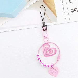 Detailed view of pink heart keychain with Mezzo Piano plaque and white beads on black cord
