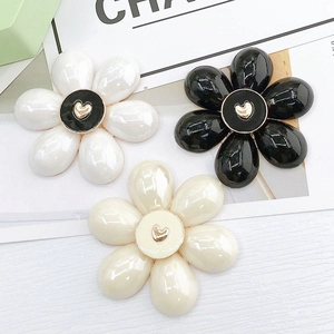 Dettaglio macro di accessori a fiore colorati con finitura perlata e motivo a cuore