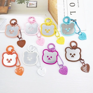 Lot de 8 porte-clés miroirs ours colorés avec breloques en cœur sur surface blanche