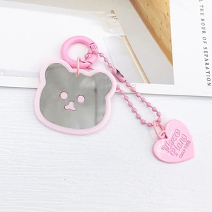 Vue détaillée d'un porte-clés miroir en forme d'ours rose avec petit pendentif cœur