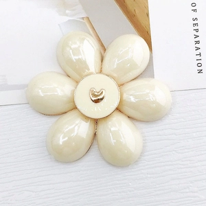 Dettaglio di un fiore di perle color crema con un centro a forma di cuore dorato