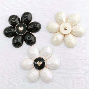 Dettaglio di accessori in lega a forma di fiore con decorazione a cuore dorato al centro