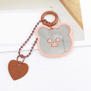 Détail du porte-clés miroir ours en acrylique rose avec breloque cœur gravée