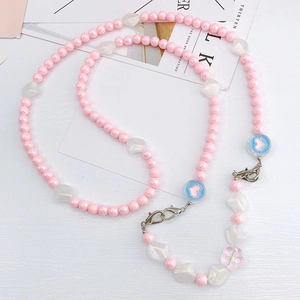Détail de la bandoulière en perles roses et cœurs en acrylique bleus pour téléphone