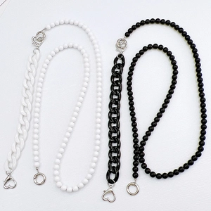 Detailed view of acrylic beaded mobile phone straps with heart-shaped metal clasps