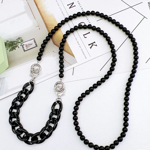 Detail view of a glossy black acrylic beaded phone strap with silver metal lobster clasps