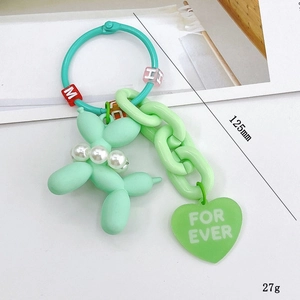 Mint green matte balloon dog keychain with pearl collar and heart charm on white background