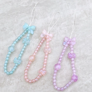 Close-up of pastel beaded phone straps with large bows in blue, pink, and purple colors